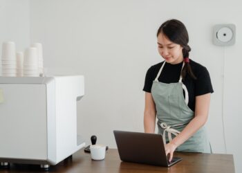 business owner using laptop behind the counter