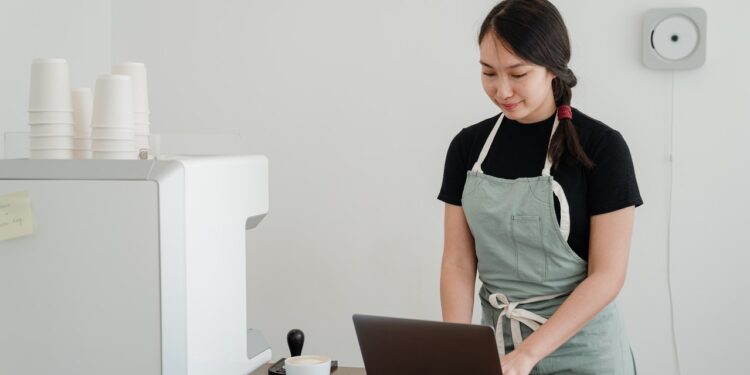 business owner using laptop behind the counter