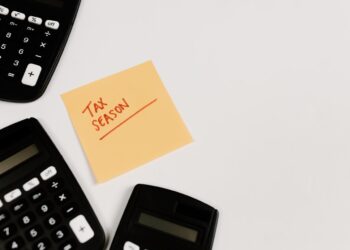 tax season written on post-it surrounded by calculators